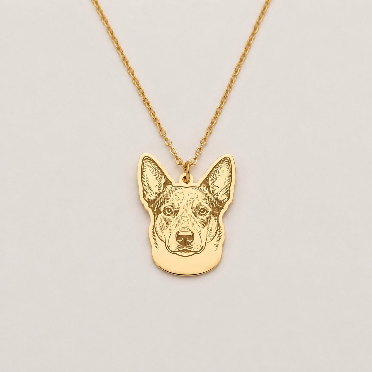 Example of a pet portrait cut to their shape on a gold necklace